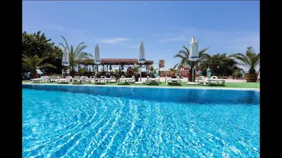 a large swimming pool with chairs and a resort at Hotel Fantasy Beach in Sveti Vlas