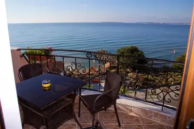 a table and chairs on a balcony overlooking the water at Hotel Fantasy Beach in Sveti Vlas