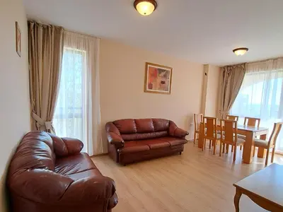a living room with a leather couch and a table at Hotel Seasons 3 in Sunny Beach