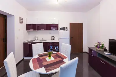 a kitchen and dining room with a table and chairs at Central Beach GUEST ROOMS in Burgas City
