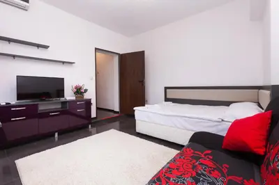 a bedroom with a bed and a tv and a couch at Central Beach GUEST ROOMS in Burgas City