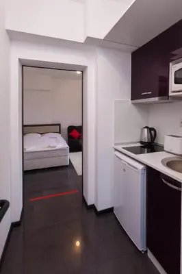 a small kitchen with a bed in a room at Central Beach GUEST ROOMS in Burgas City