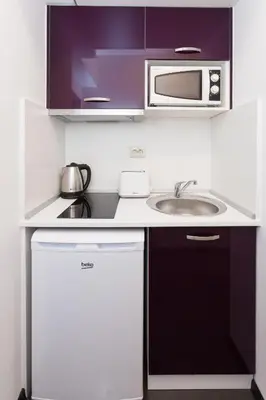 a small kitchen with a sink and a microwave at Central Beach GUEST ROOMS in Burgas City