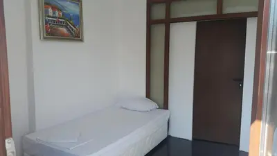 a bed in a room with a painting on the wall at Central Beach GUEST ROOMS in Burgas City