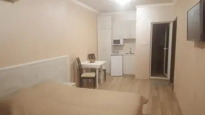 a small white room with a table and a kitchen at Apartments Dani in Pomorie