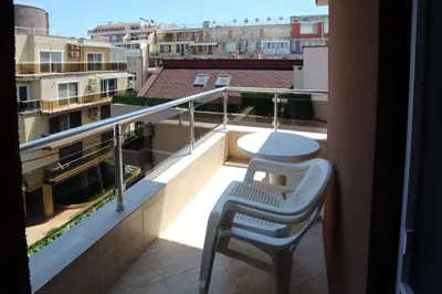a balcony with a table and a chair on a building at Apartments Dani in Pomorie