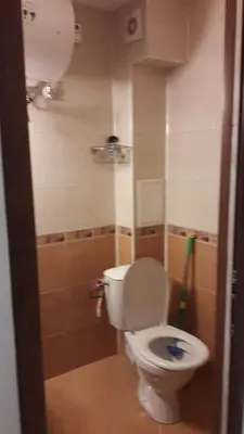 a bathroom with a white toilet in a room at Sea Bedroom Apartments in Nesebar