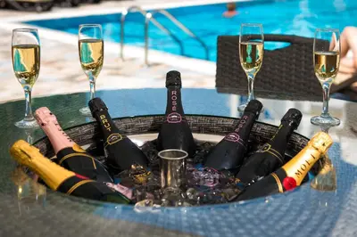 a bunch of bottles of wine on a table with glasses at Siena Palace in Primorsko