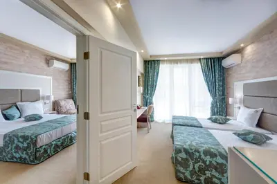 a hotel room with two beds and a window at Siena Palace in Primorsko