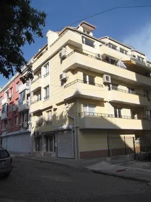 a large white building with a garage in front of it at Apartment Sredna Gora in Burgas City