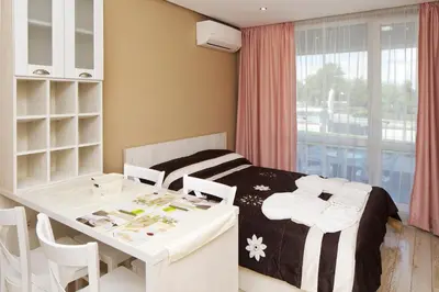a bedroom with a bed and a table and chairs at Aparthotel Paradiso in Nesebar