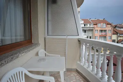 a white table and chair on a balcony at Hotel Eos in Kiten