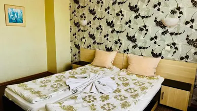 a bedroom with two beds with a floral wallpaper at Hotel Eos in Kiten