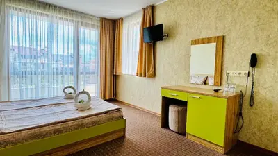 a hotel room with a bed and a window at Hotel Eos in Kiten