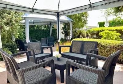 a group of wicker chairs and a table under an umbrella at Family Hotel Kontesa in Lozenets