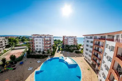 an apartment with a swimming pool and some buildings at Riviera Fort Beach Apartments in Ravda