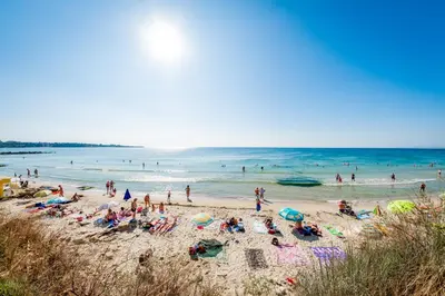 a group of people on a beach with the ocean at Riviera Fort Beach Apartments in Ravda