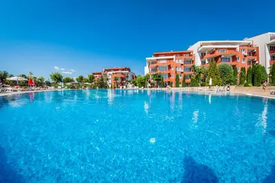 a large pool of blue water in front of buildings at Green Fort Noks Apartments in Sunny Beach