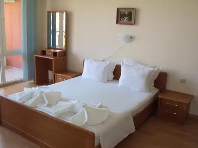 a bedroom with a bed with white sheets and pillows at Green Fort Noks Apartments in Sunny Beach
