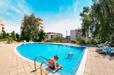 a woman is sitting in a swimming pool at Crown Fort Club in Sveti Vlas