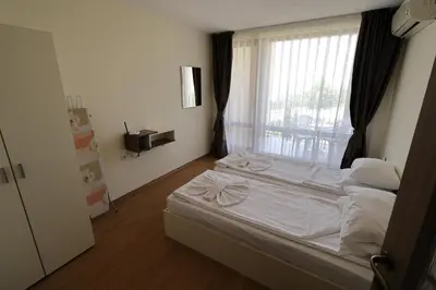 a bedroom with a white bed and a window at Crown Fort Club in Sveti Vlas