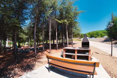 a park bench in a park with trees and a stove at Imperial and Crown Fort Noks Grand Resort in Sveti Vlas