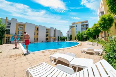 a man and a woman standing next to a swimming pool at Imperial and Crown Fort Noks Grand Resort in Sveti Vlas