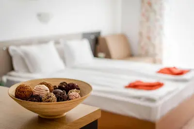 a bowl of food on a table in front of a bed at Step Hotel in Sunny Beach