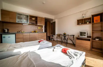 two beds in a room with a kitchen at Step Hotel in Sunny Beach