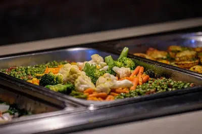a buffet of food with broccoli and other vegetables at Imperial Palace Hotel in Sunny Beach