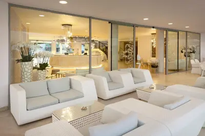 a living room with white couches and a table at Hotel Residence Dune - Free Beach Access in Sunny Beach