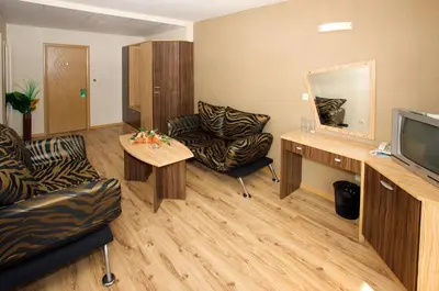 a living room with a tv and a couch and a table at Hotel Kotva - All Inclusive in Sunny Beach