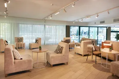 a waiting room with chairs and tables and windows at Hotel Marvel All Inclusive - FULLY RENOVATED FREE Beach Access in Sunny Beach