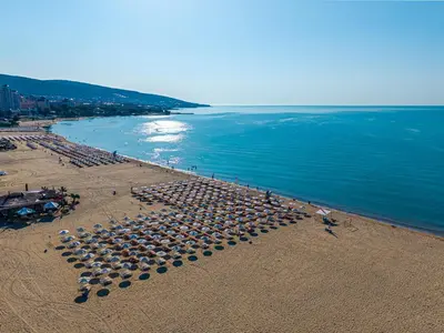 a group of umbrellas on a beach near the water at Hotel Marvel All Inclusive - FULLY RENOVATED FREE Beach Access in Sunny Beach