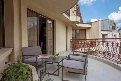 a balcony with chairs and tables on a building at Hotel Perfect in Varna City