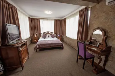 a bedroom with a bed and a tv and a mirror at Hotel Perfect in Varna City
