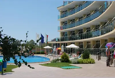 a hotel with a swimming pool in front of a building at Julia Family Apartments in Sunny Beach