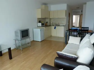 a living room with a couch and a kitchen at Julia Family Apartments in Sunny Beach