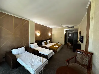 a hotel room with two beds and a couch at Art Hotel Babylon in Sunny Beach
