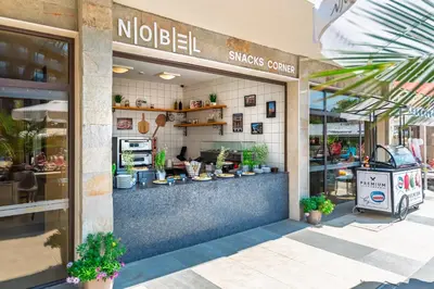 a restaurant with a counter with potted plants in front of it at Hotel Nobel Ultra All Inclusive - FREE Beach Access in Sunny Beach