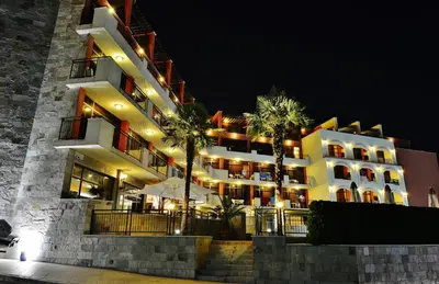 a large building with palm trees in front of it at Hotel Nobel Ultra All Inclusive - FREE Beach Access in Sunny Beach