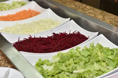 a bunch of different vegetables in white bowls on a counter at Les Magnolias Hotel in Primorsko