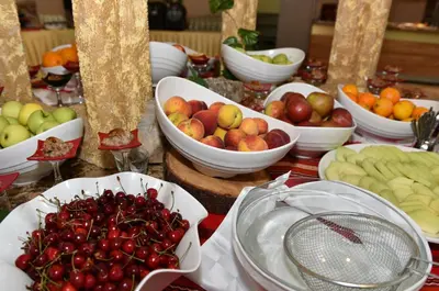 a table with bowls of apples and other fruits on it at Les Magnolias Hotel in Primorsko