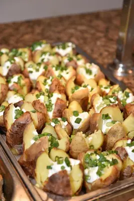 a tray of food with potatoes and green onions at Villas Ropotamo in Primorsko