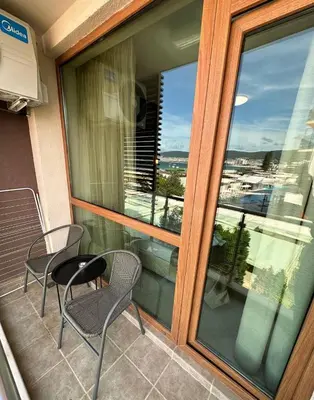 a balcony with two chairs and a table and a window at Briz Beach apartments - section B in Sunny Beach