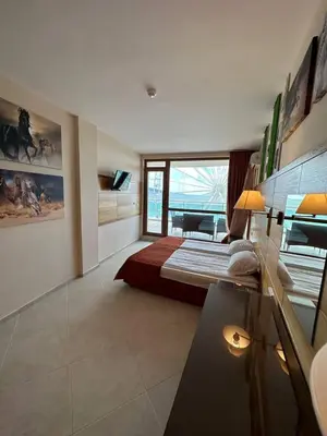 a bedroom with a large bed and a large window at Briz Beach apartments - section B in Sunny Beach