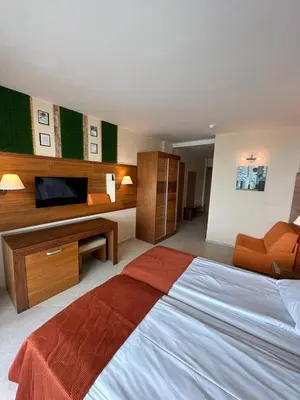 a bedroom with a large bed and a television at Briz Beach apartments - section B in Sunny Beach
