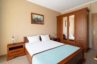 a bedroom with a large bed and a mirror at Festa Pomorie Resort in Pomorie