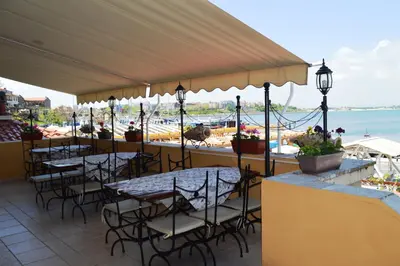 a restaurant with tables and chairs and a view of the ocean at Stankoff Hotel in Nesebar