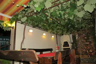 a table and a bench with a table and a tree at Hotel Strinava in Primorsko